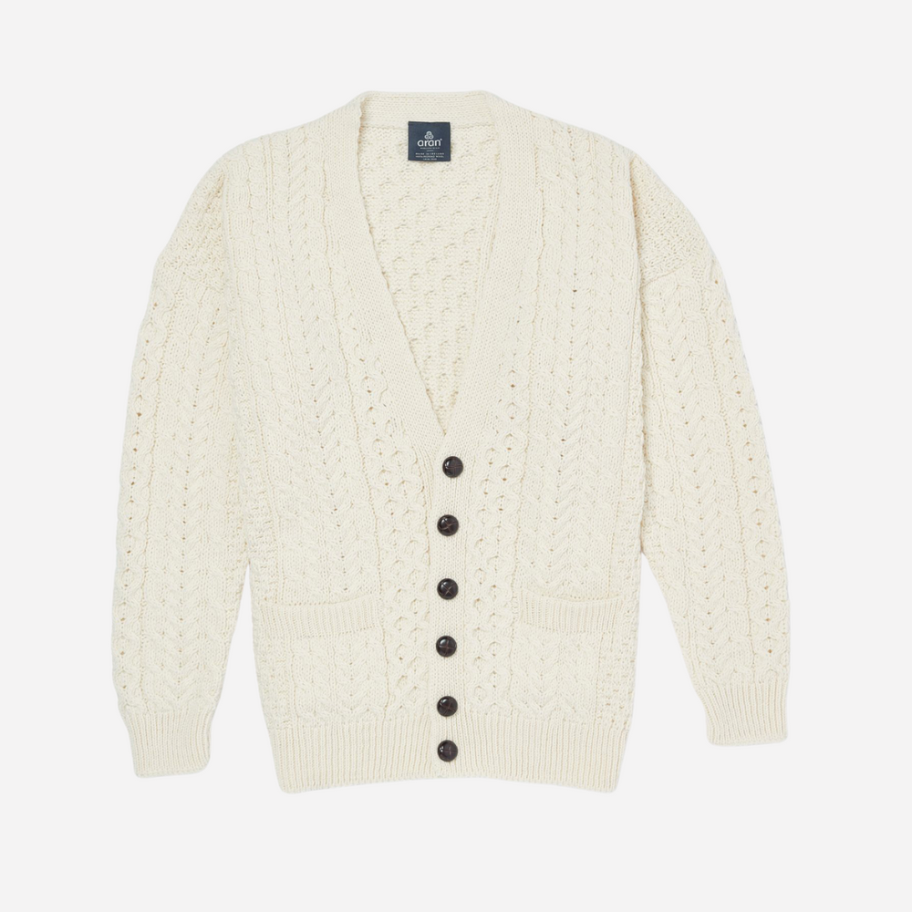Cream-colored cardigan with black buttons on a white background