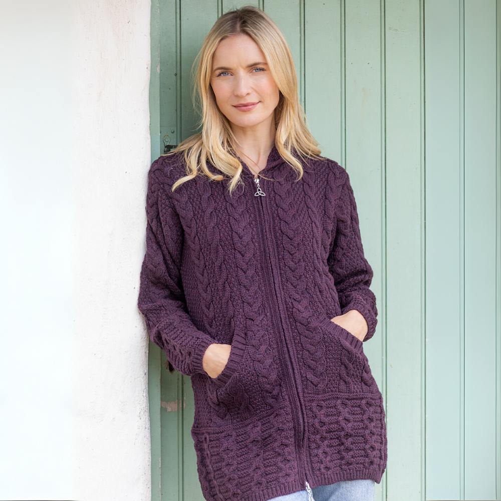 Woman wearing a purple zip-up sweater with a green door background