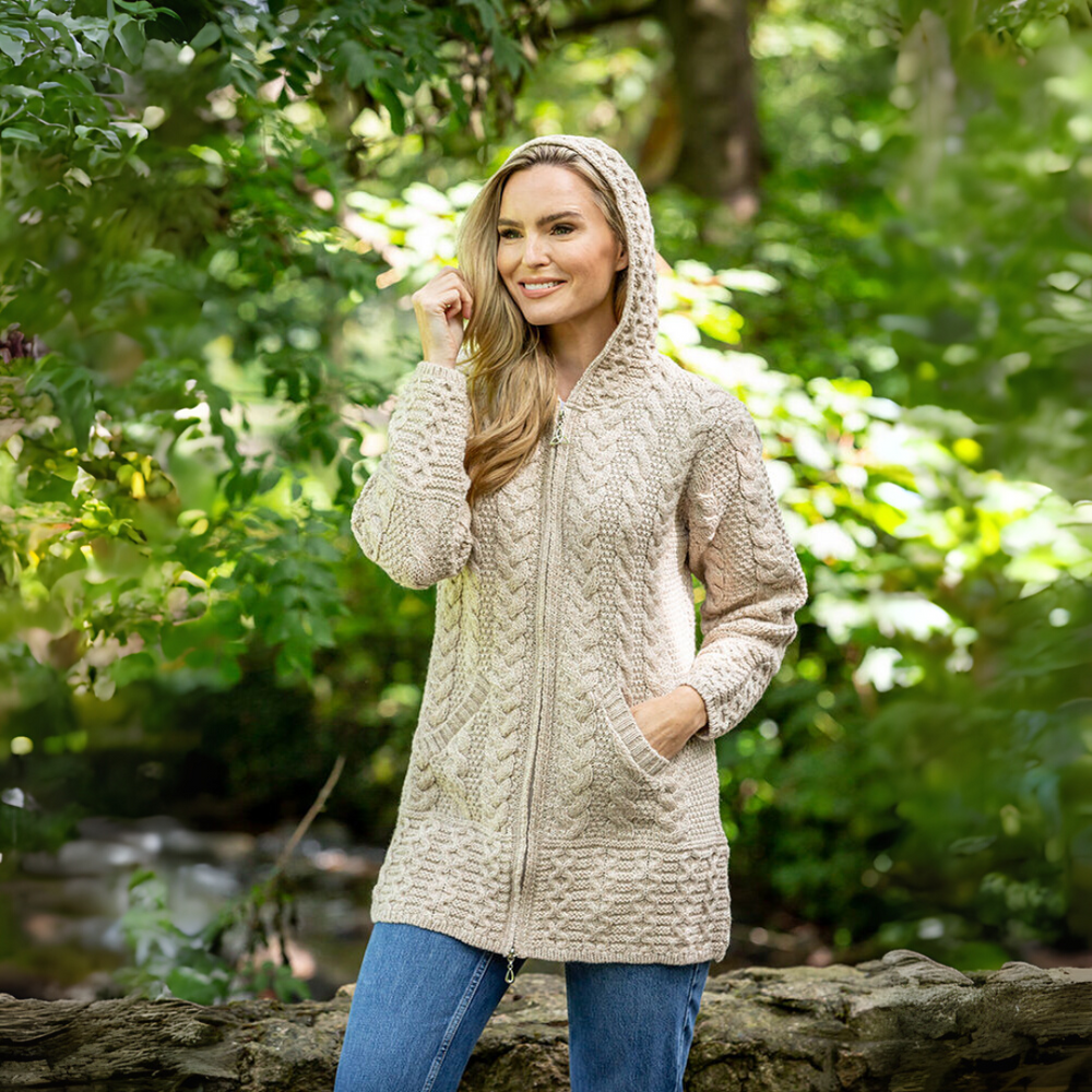 Woman wearing a beige hooded jacket in a forest setting