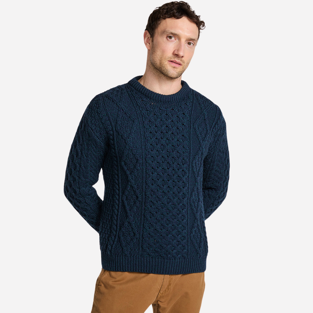 Man wearing a dark blue knitted sweater on a white background