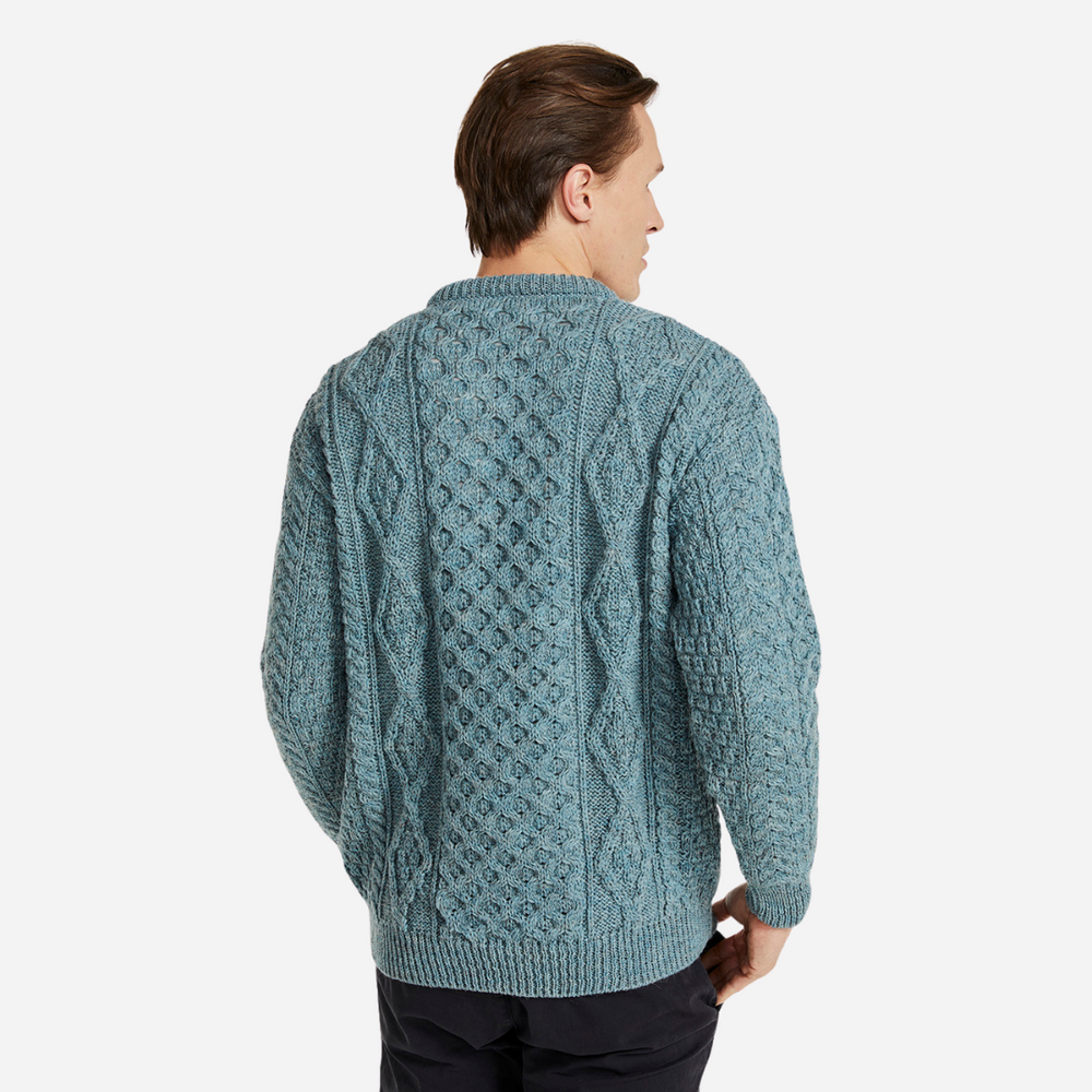 Man wearing a teal knitted sweater on a white background