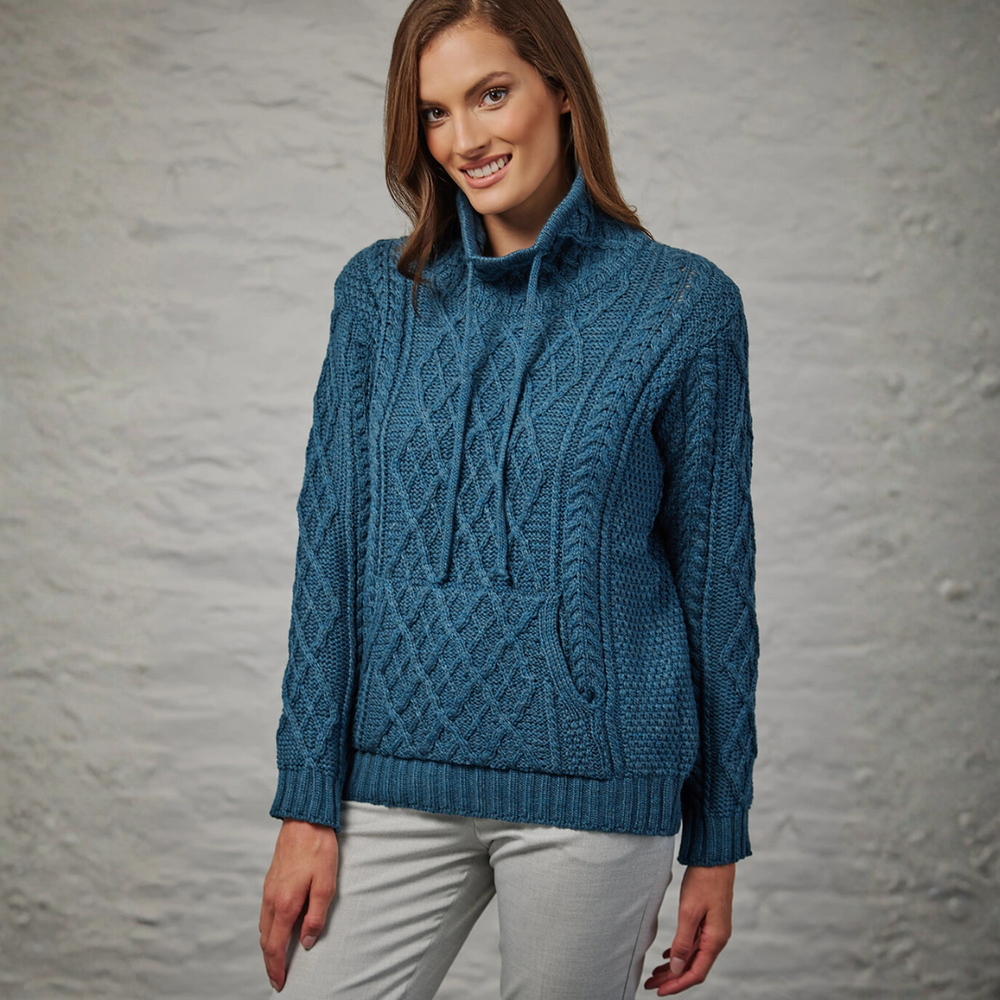 Woman wearing a blue knitted sweater against a gray background