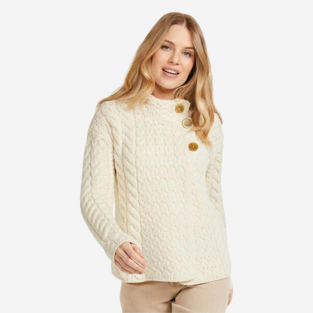 Woman wearing a cream knitted sweater with button details on a white background