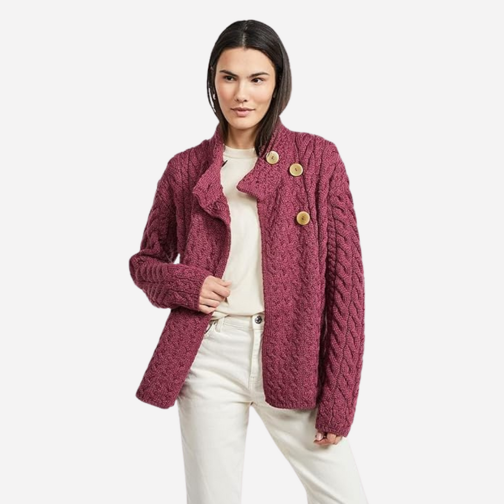Woman wearing a pink textured jacket with gold buttons on a white background