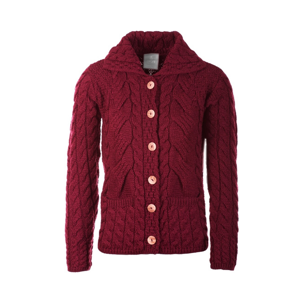 A red cable knit button-up cardigan with a round neckline and buttons down the front, made from merino wool.