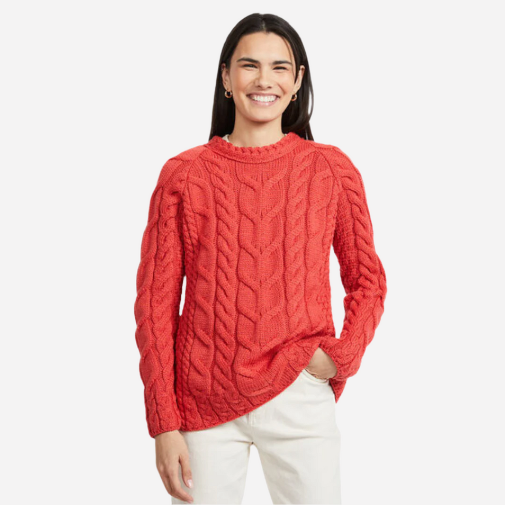 Woman wearing a red cable knit sweater on a white background