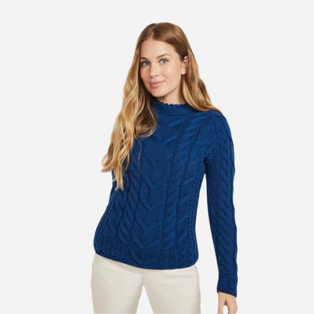 Woman wearing a blue cable knit sweater on a white background