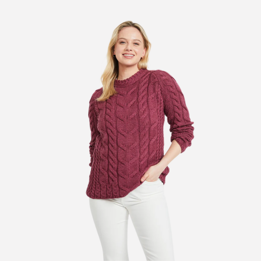 Woman wearing a maroon cable knit sweater on a white background