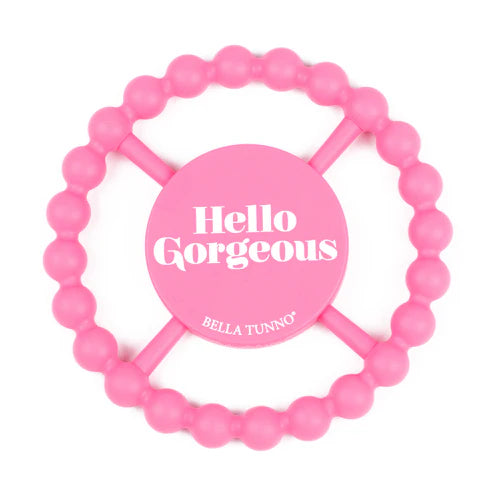 Pink teething ring with 'Hello Gorgeous' and 'Bella Tunno' text on a white background