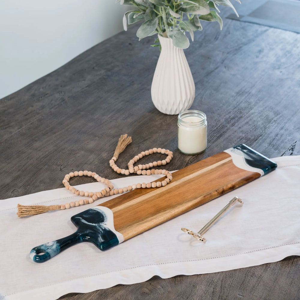 This baguette board made of Acacia wood and crafted with natural eco-friendly navy/white/metallic epoxy
