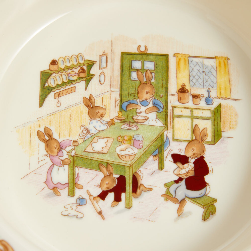 Illustration of rabbits in a kitchen setting on a decorative plate.