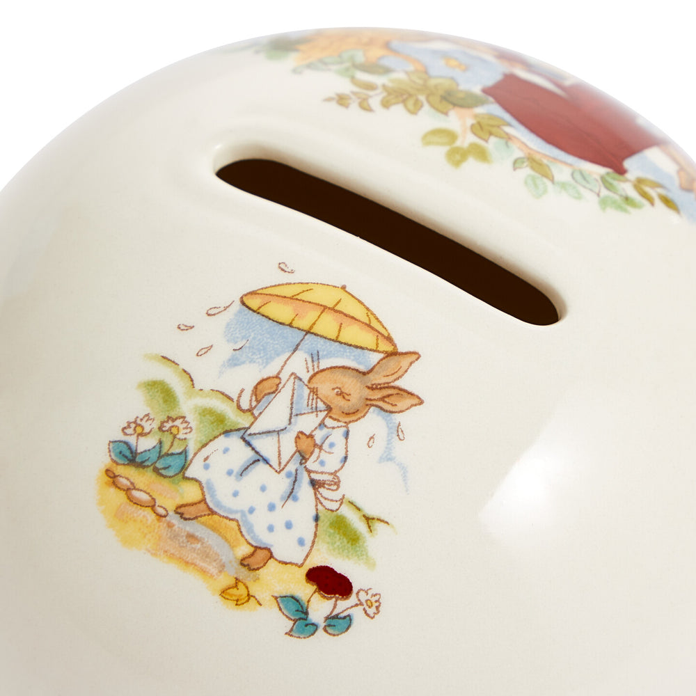 Children's piggy bank with a rabbit design holding an umbrella on a white background