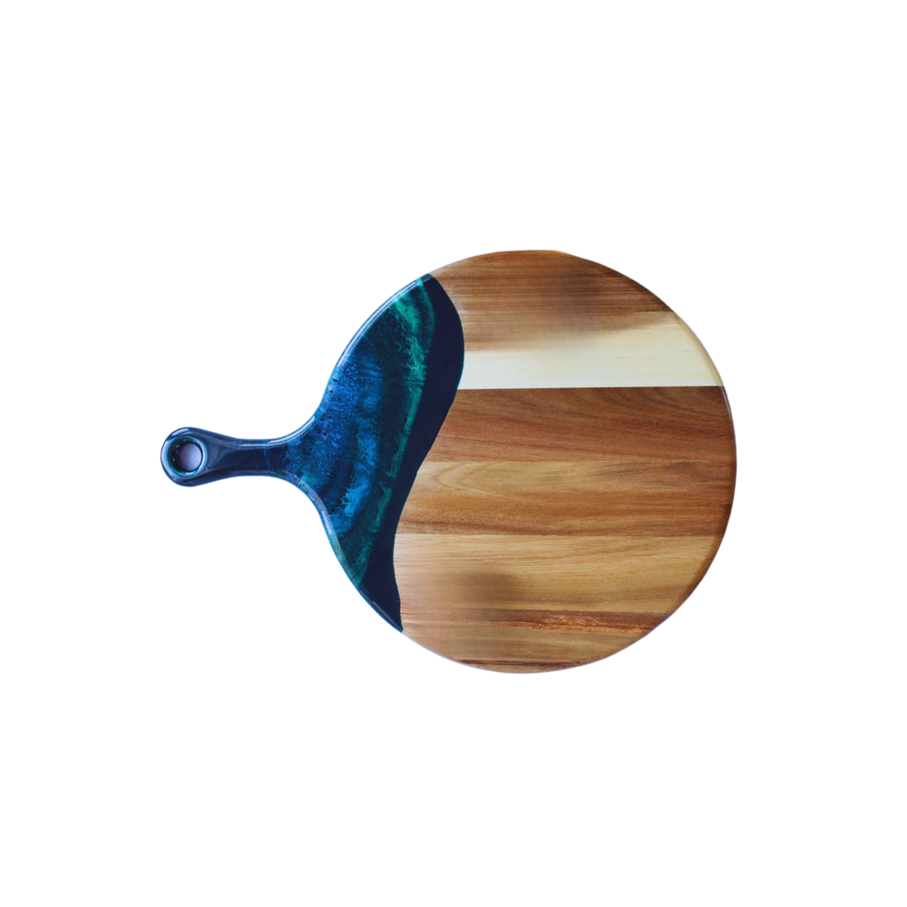 A 12" diameter cheese paddle by Lynn & Liana combines Acacia hardwood and an eco-friendly Northern lights theme epoxy.