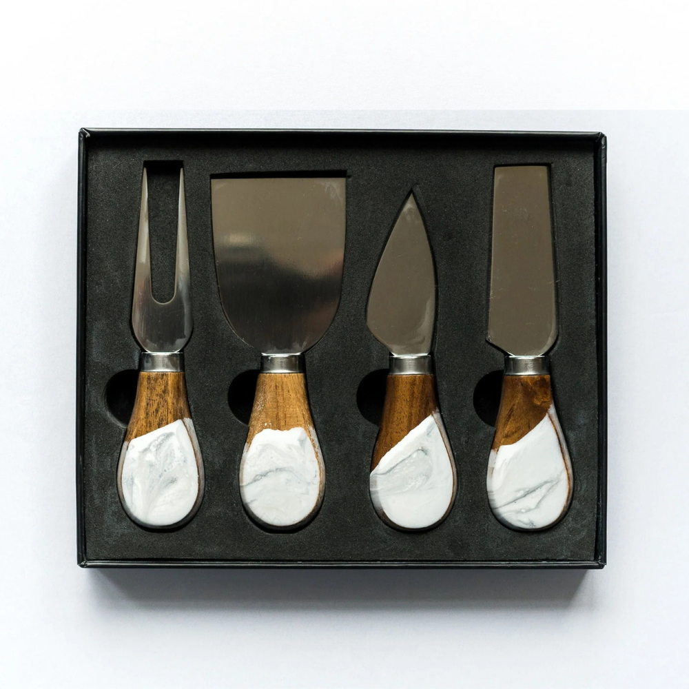 A set of four cheese knives with wooden handles and stainless steel blades, displayed in a black box.