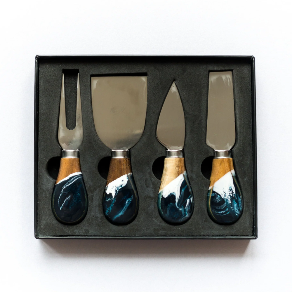 A set of four cheese knives with wooden handles and stainless steel blades, displayed in a black box.