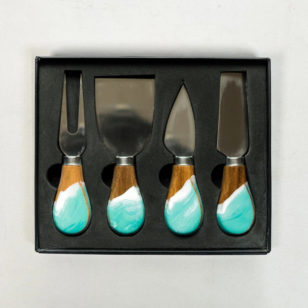 A set of four cheese knives with wooden with caribbean blue epoxy handles and stainless steel blades, displayed in a black box.