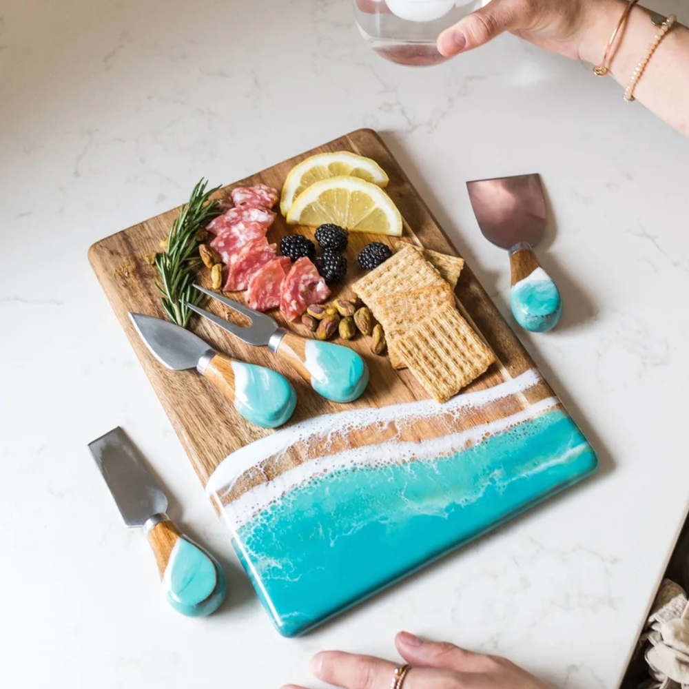 A set of four cheese knives with wooden with caribbean blue epoxy handles and stainless steel blades