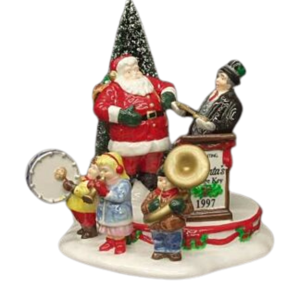 Santa Claus is  in front of a Christmas tree, with a child band in front.