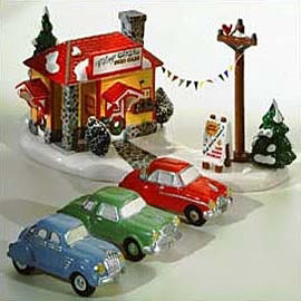 Christmas village scene with houses, cars, and trees on a white background