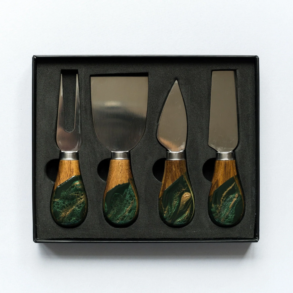 A set of four cheese knives with wooden handles and stainless steel blades, displayed in a black box.