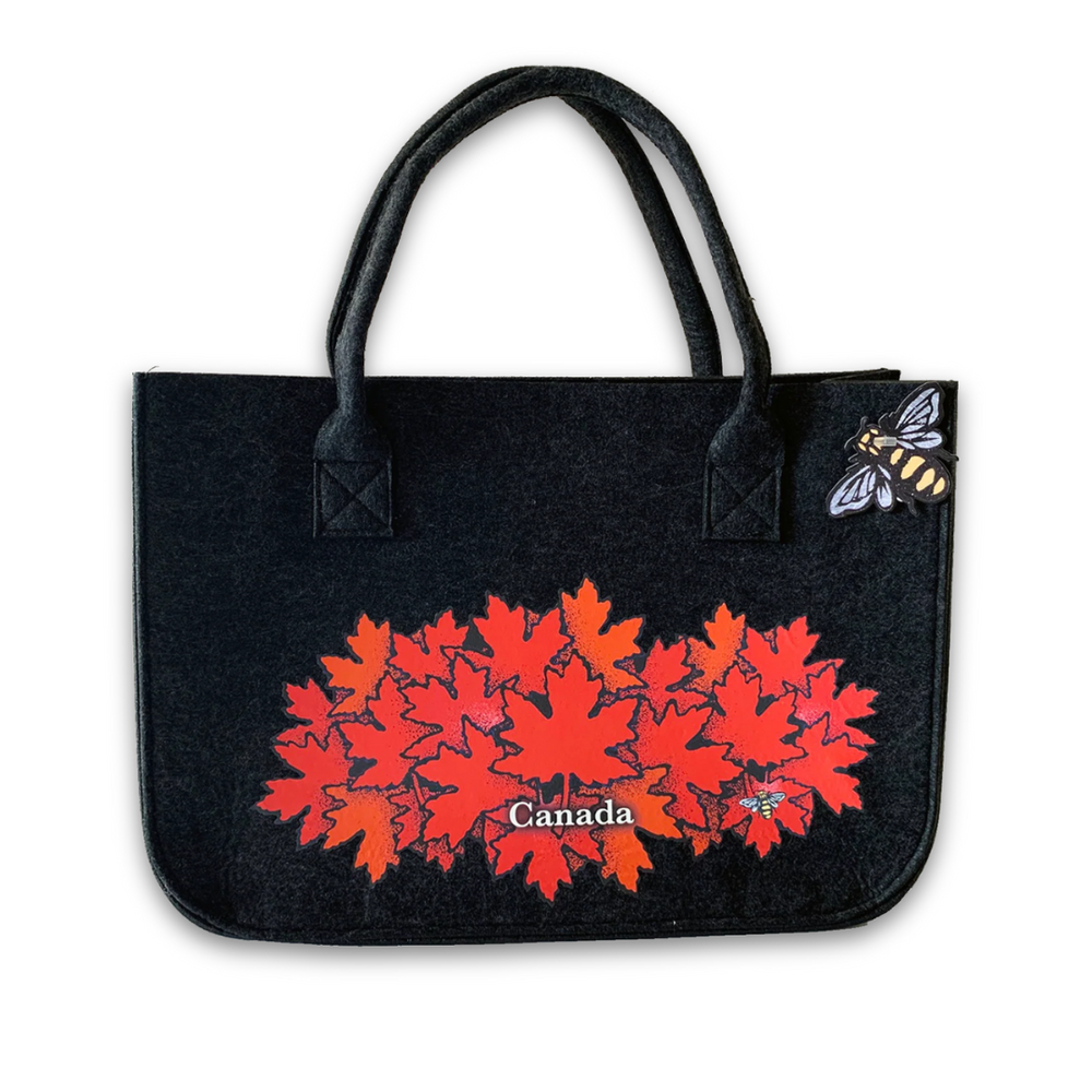 Black tote bag with red maple leaf design and 'Canada' text on a white background