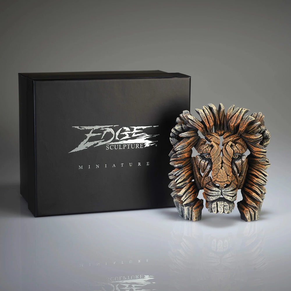 A miniature lion bust sculpture  with a box in the background displaying the brand 'Edge Sculpture'.