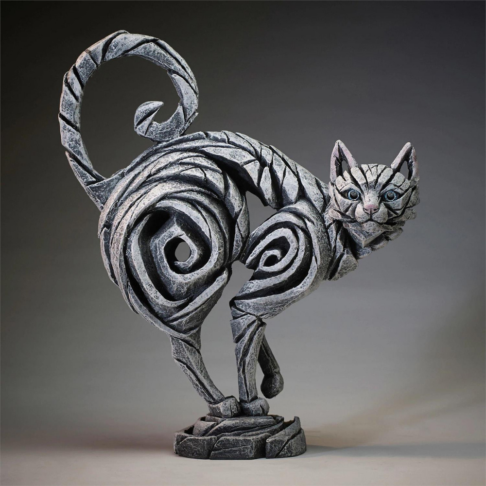 Decorative cat sculpture with swirling patterns on a gray background