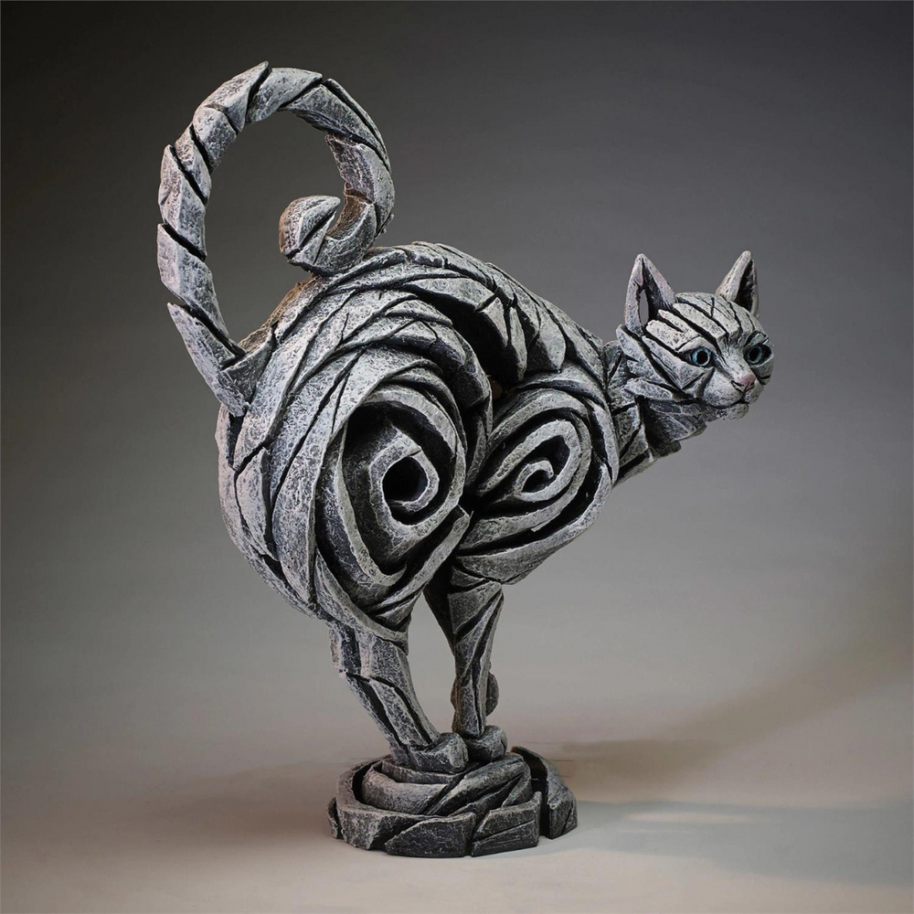 Decorative cat sculpture with swirling patterns on a gray background