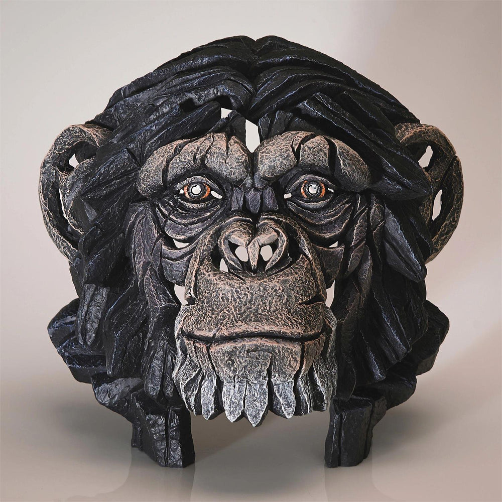 Decorative ape head sculpture on a plain background