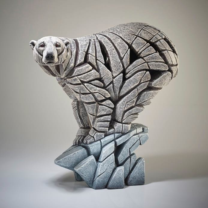 A sculpture of a polar bear with a stone-like appearance, created by EDGE SCULPTURES.
