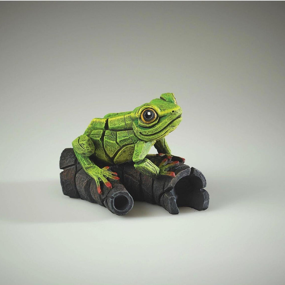 Green frog figurine on a gray background