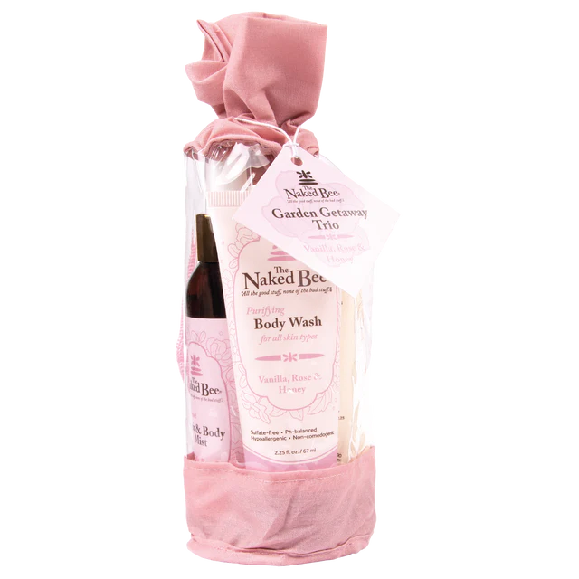 Naked Bee body wash and bottle in a pink drawstring bag on a white background