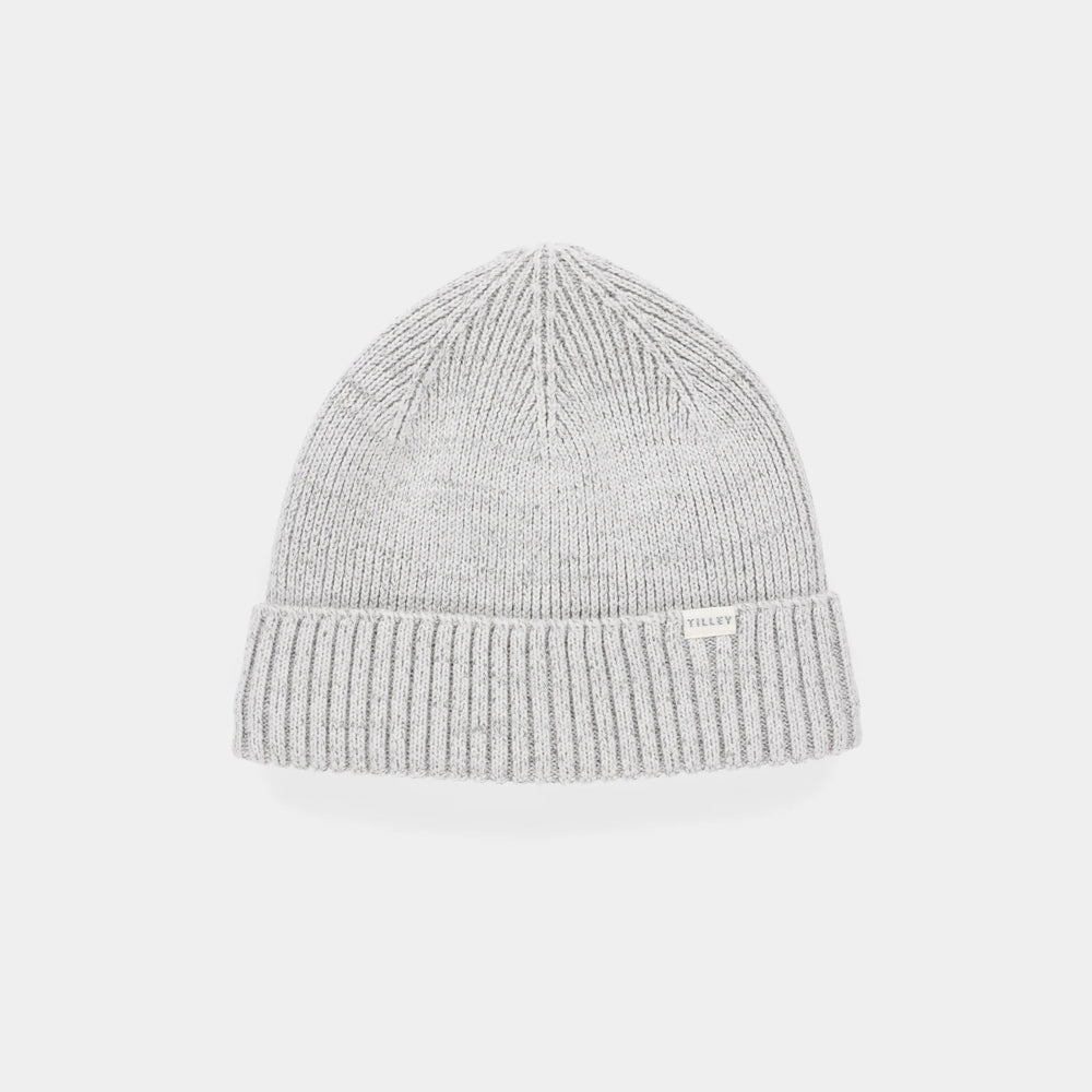 A light gray ribbed knit beanie hat with a small white brand tag on the front cuff, shown against a plain light gray background.