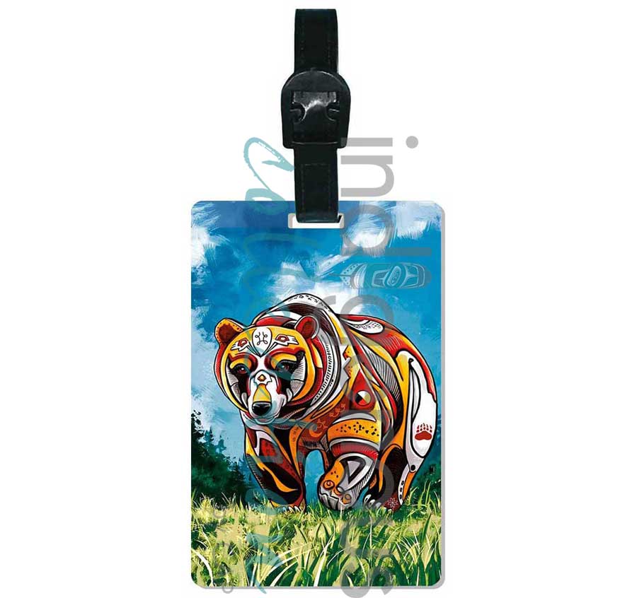 Colorful bear design on a luggage tag with a blue sky and green grass background.