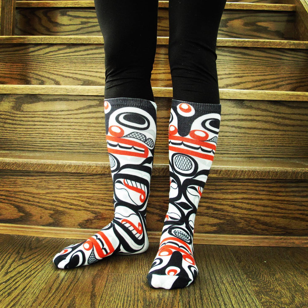 Person wearing knee-high patterned socks on wooden stairs