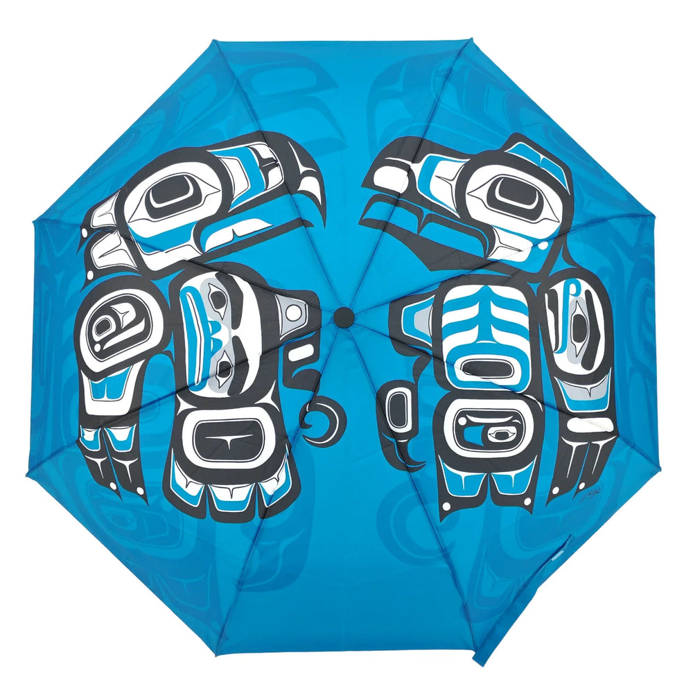 Blue umbrella with black and white bear design on a white background