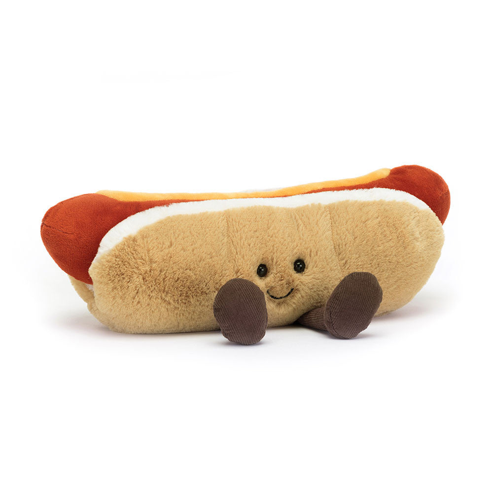 A plush toy designed to look like a hot dog with a beige and white fur bread bun and a red sausage representing the hot dog.