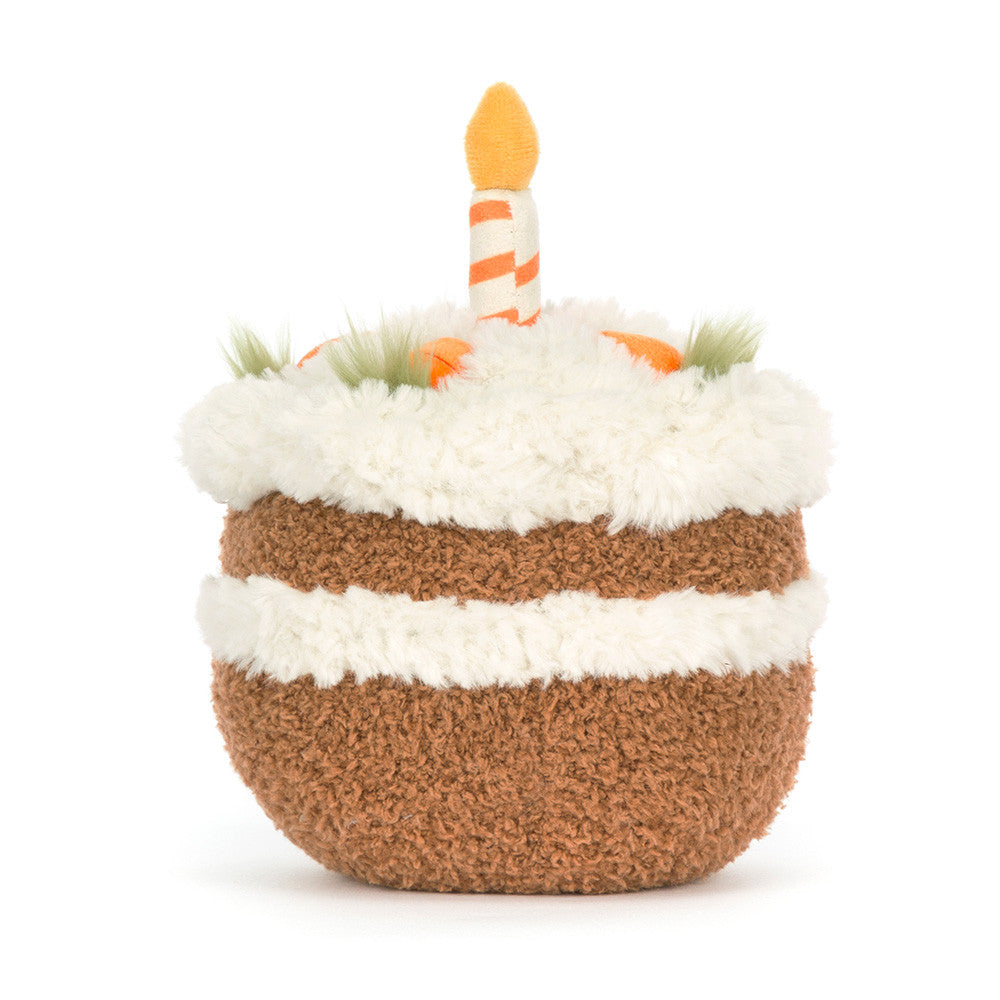 Toy resembling a birthday cake with white frosting, brown base, and a candle on a white background