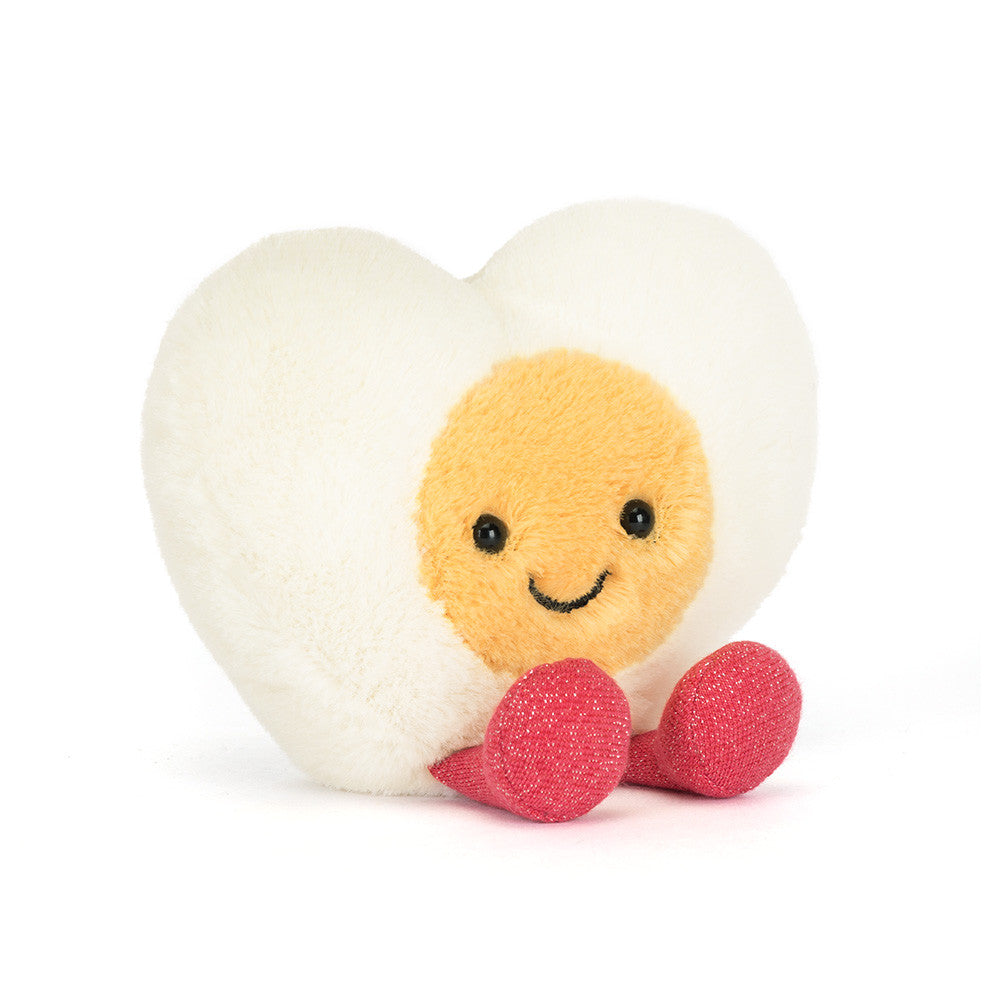 Heart-shaped plush toy with a smiling face on a white background