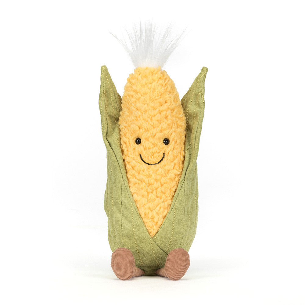Plush toy resembling a corn on the cob with a smiling face on a white background