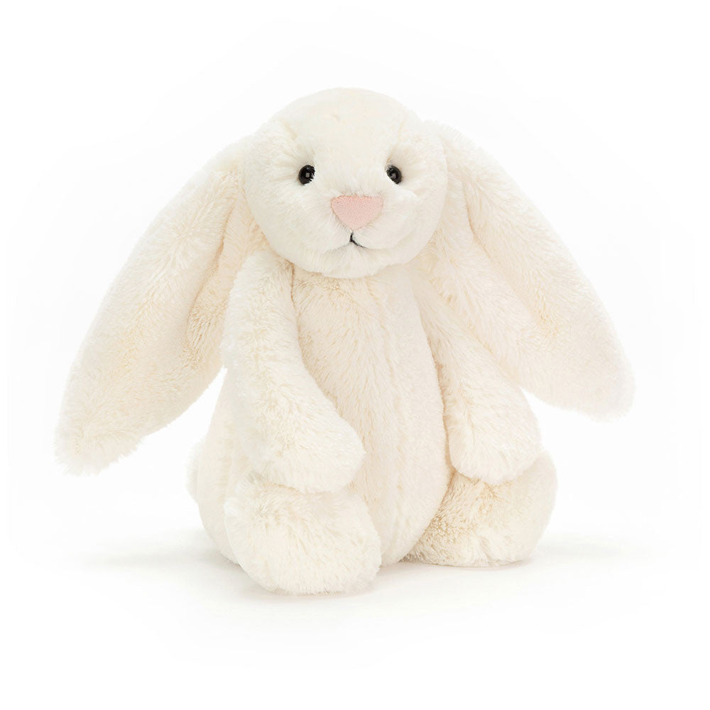 A plush toy resembling a cream-colored bunny with long ears, sitting upright.
