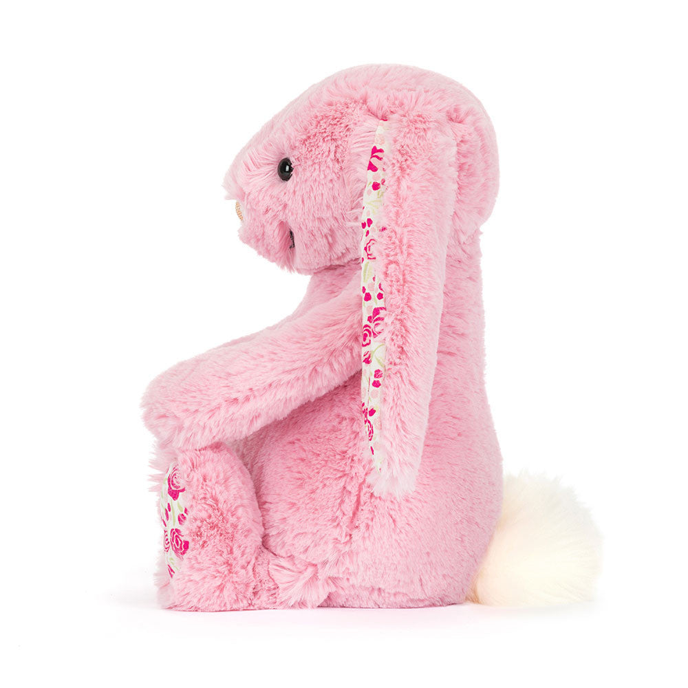Pink plush bunny toy with floral pattern on a white background