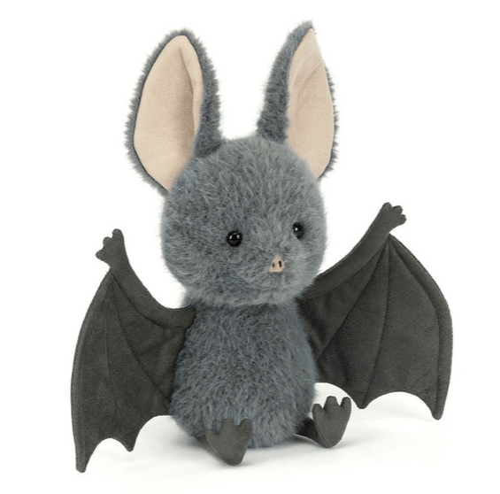 A plush toy bat in dark gray with large beige inner ears and dark gray wings, sitting against a plain white background.