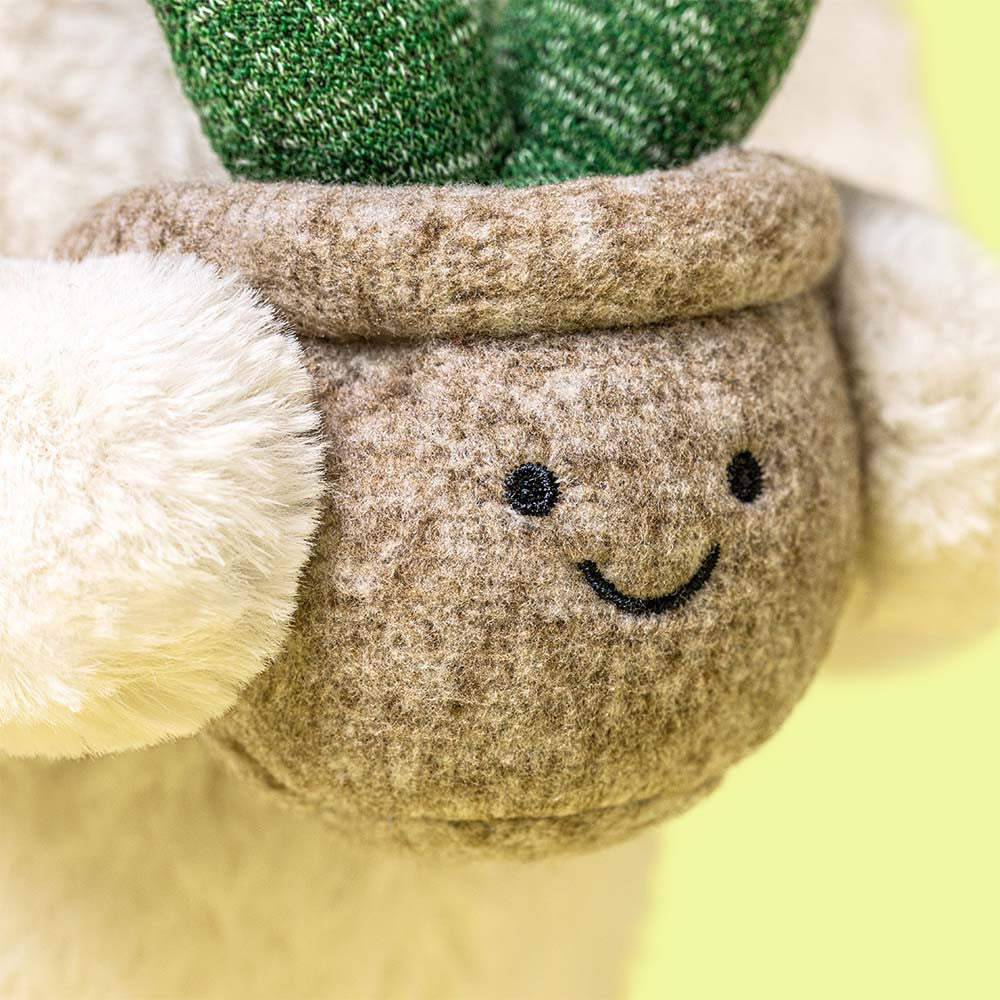 Close-up of a plush toy with a smiling face and green top hat.