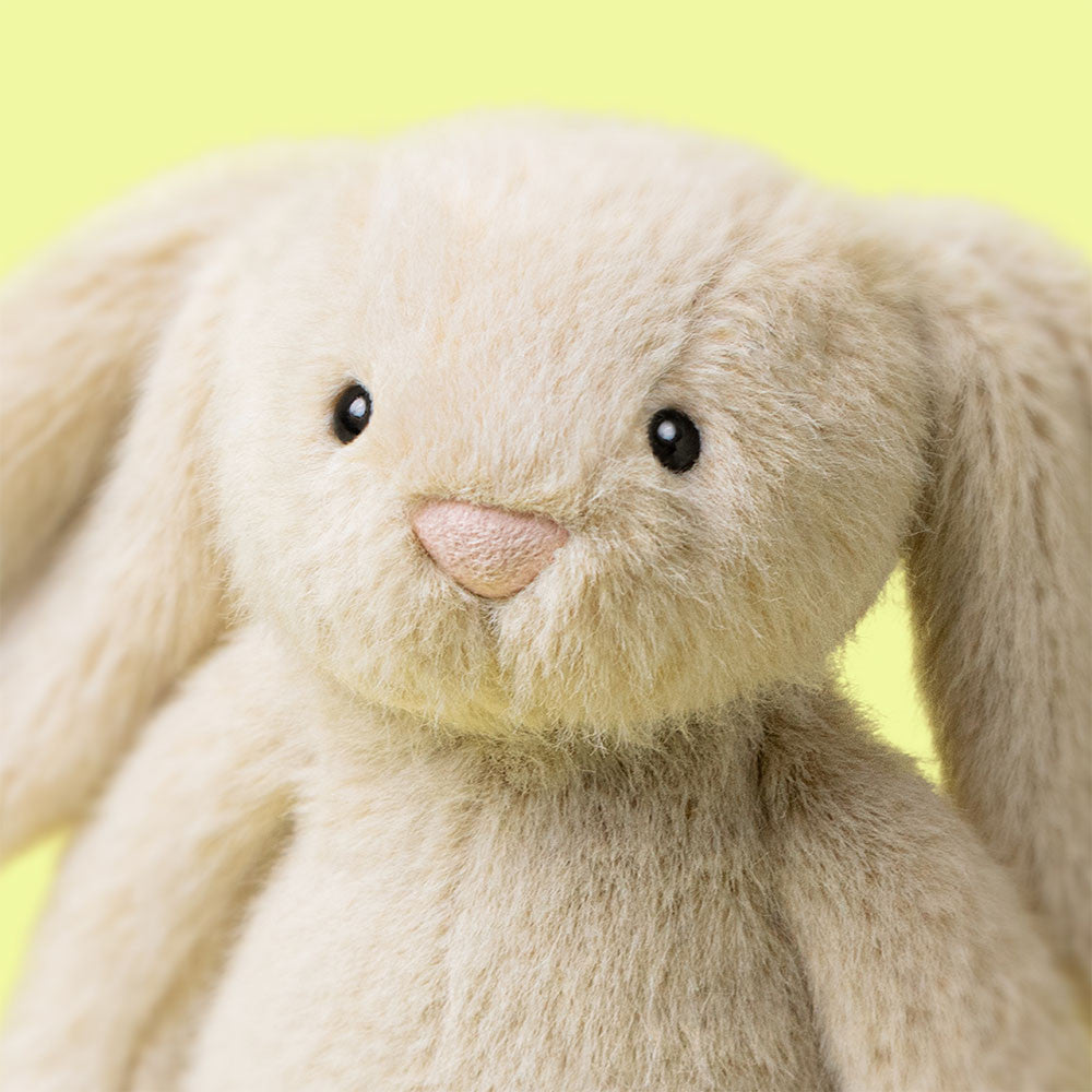 Close-up of a plush bunny toy with a yellow background