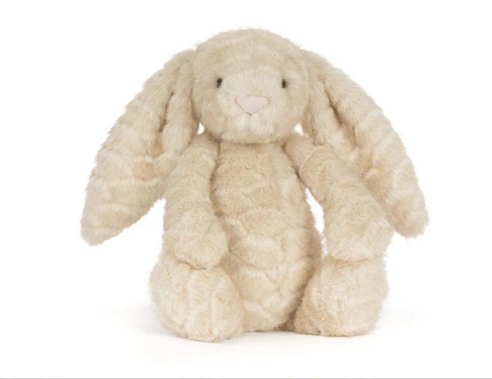 A plush stuffed bunny toy in a warm cream or beige color, sitting against a plain white background.