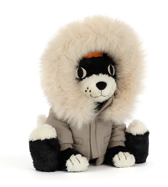 A plush dog toy wearing a beige parka and a large cream-colored faux fur hood, set against a plain white background.