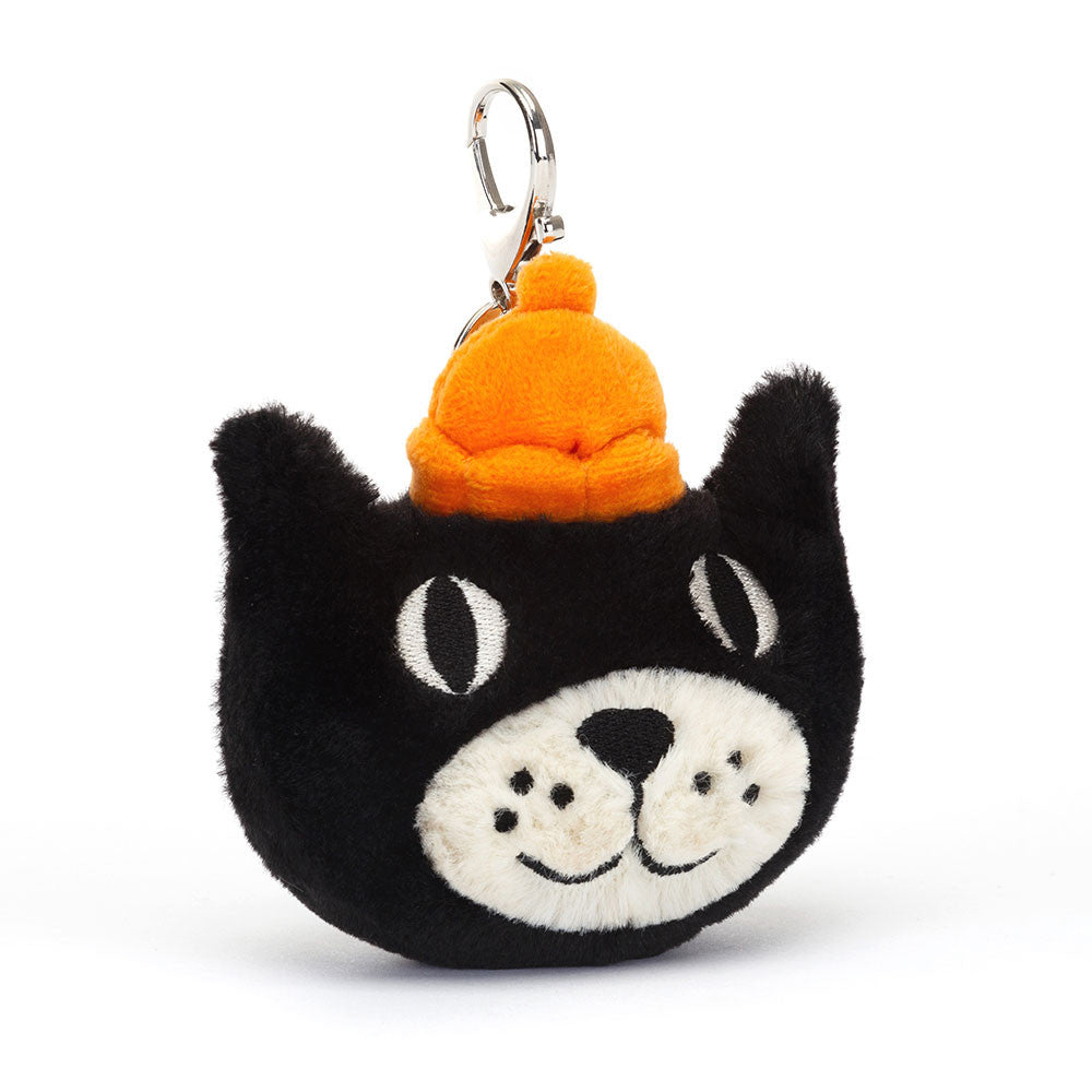 A plush black and cream colored cat bag charm with an orange jelly crown and a silver claw clip.