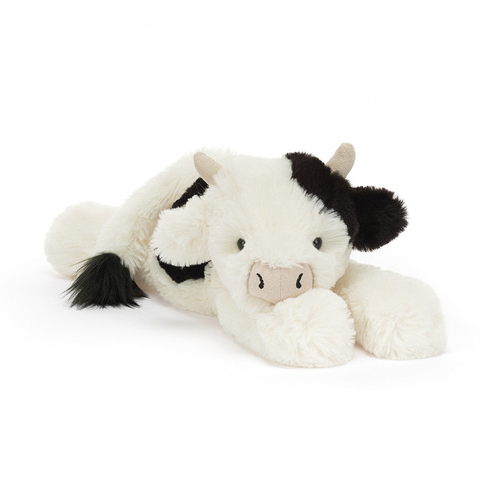 White plush cow toy with black accents on a white background