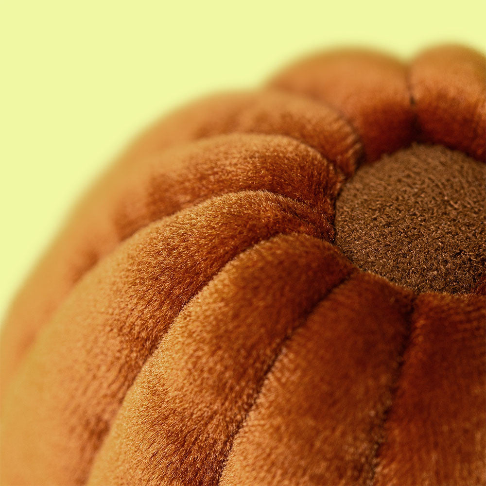 Close-up of a textured brown fabric with a yellowish-green background
